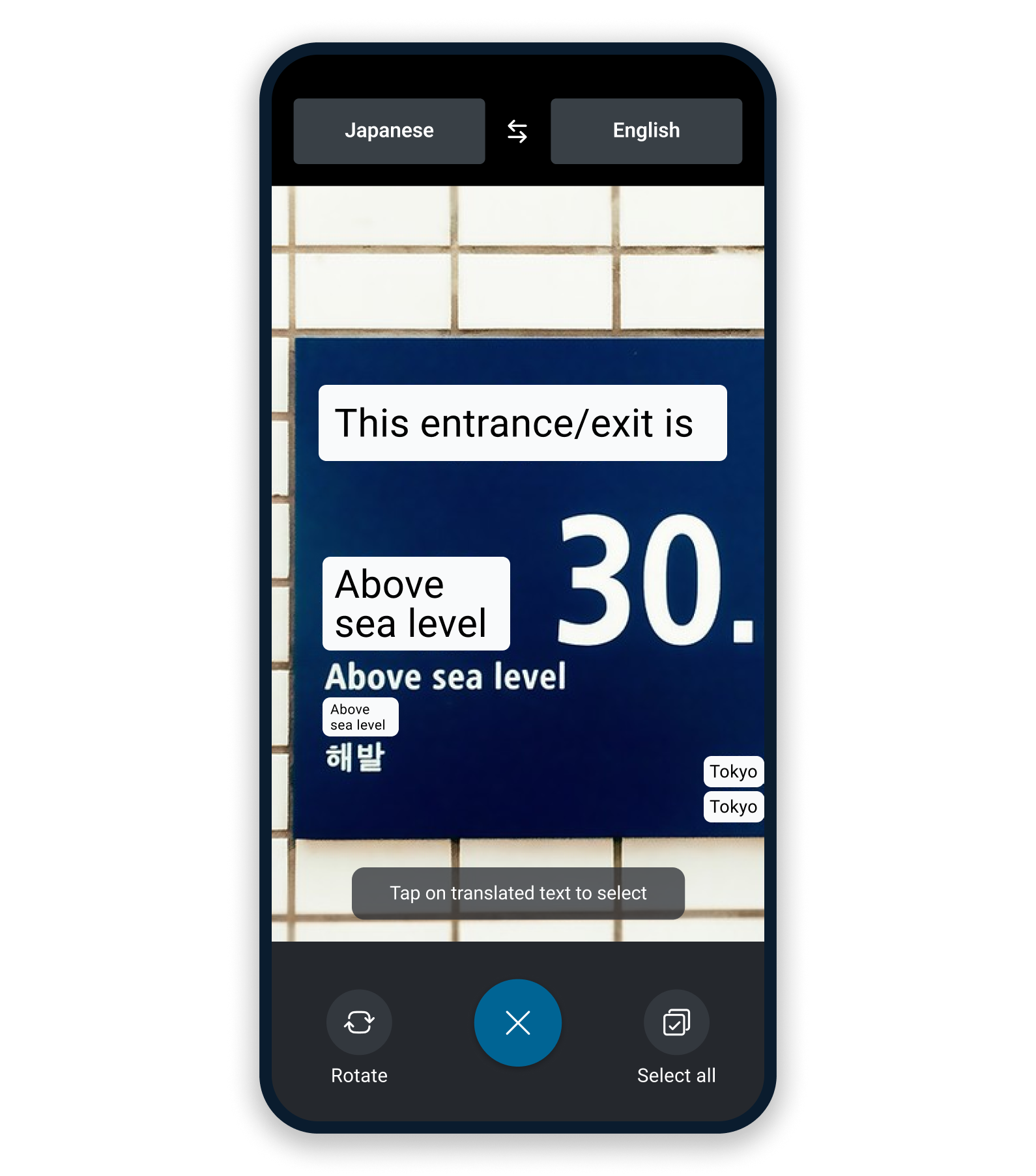 DeepLアプリのカメラ機能で日本語から英語に翻訳された道路標識を表示するスマートフォン